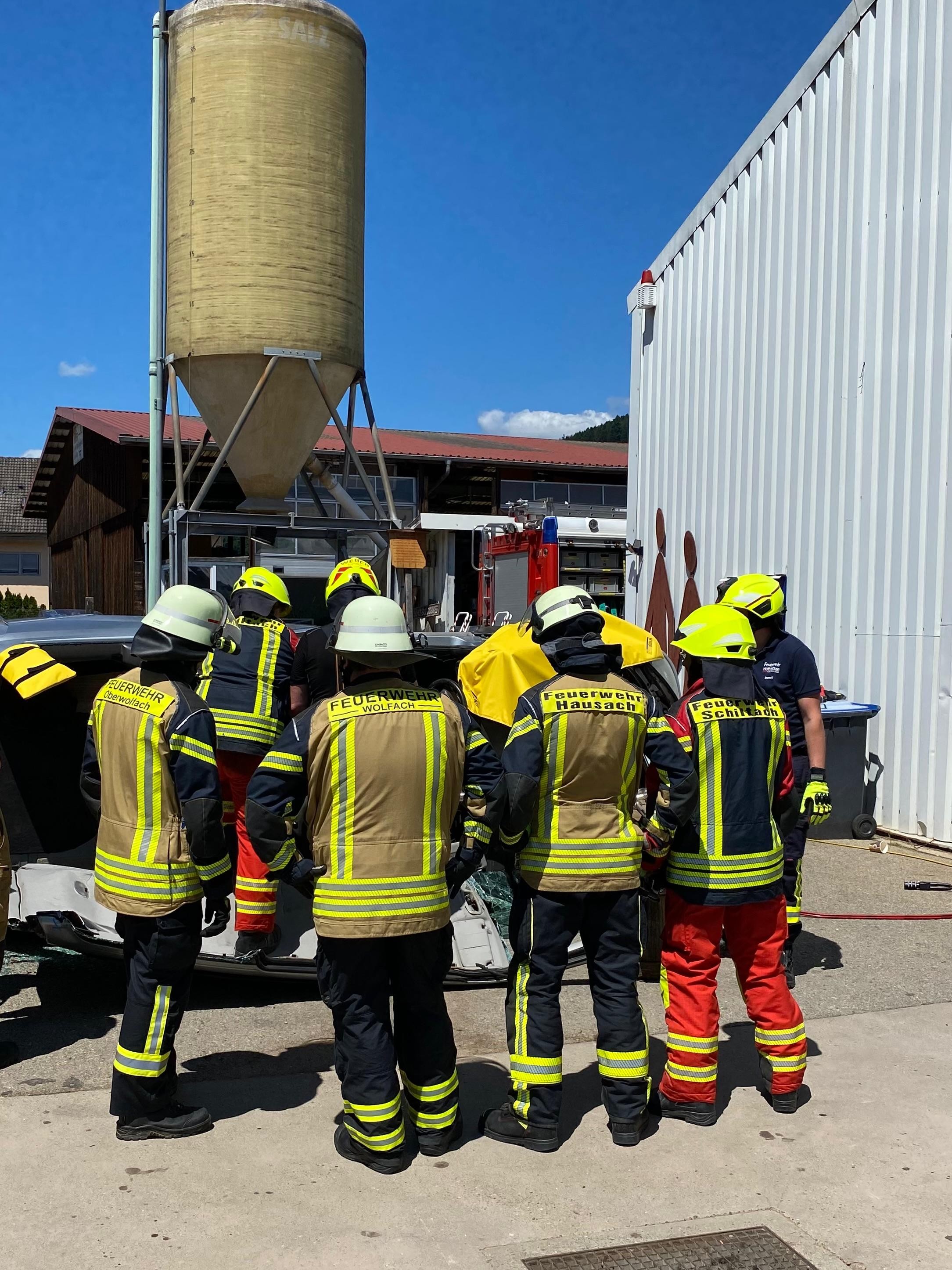 Feuerwehrleute schauen den Kameraden bei der Arbeit über die Schulter