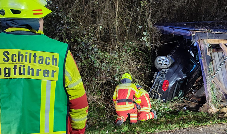 Feuerwehrleute befestigen das verunfallte Fahrzeug an der Seilwinde des Rüstwagens