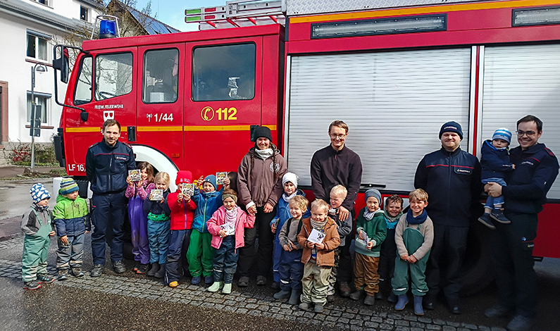 Kinder und Betreuer vor einem Lösschfahrzeug